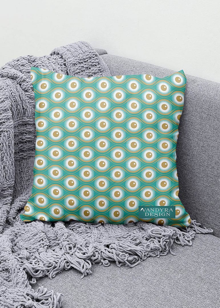 Stoffdesign. Kissen auf Sessel mit einem geometrischen Augenmuster in Beige, Creme und Mint. Auf dem Bild ist das Label - der Schriftzug Vandyra Design von der Designerin zusehen.