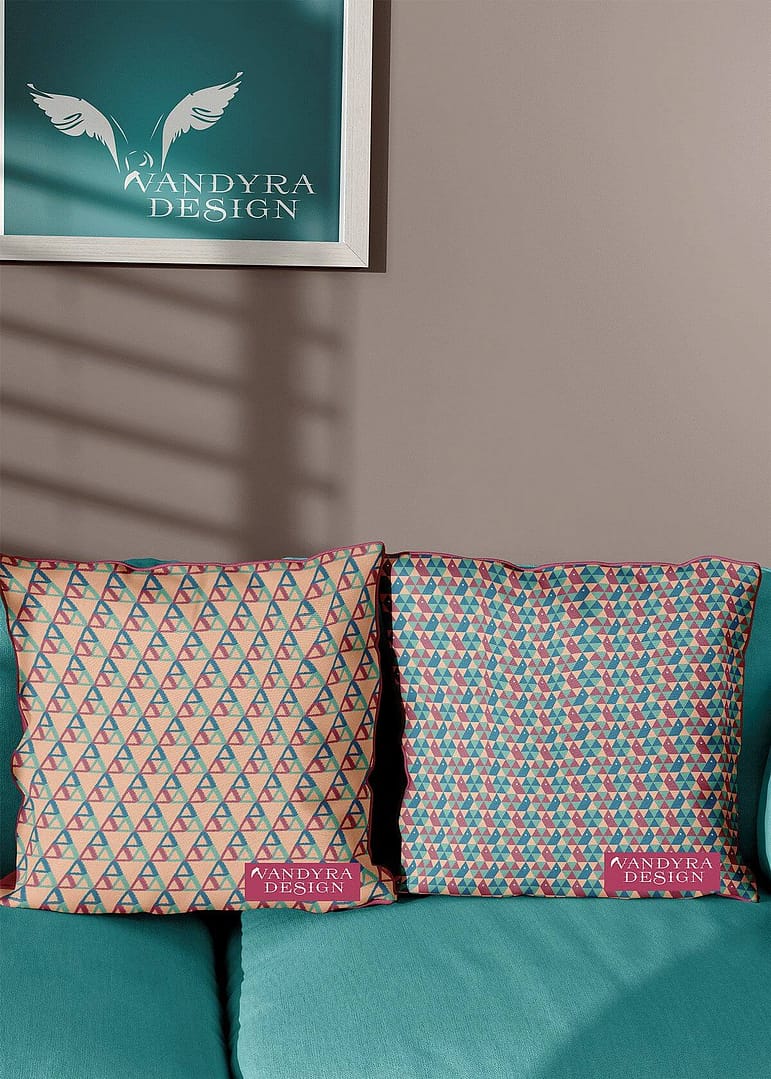 Stoffdesign. Zwei Kissen auf einer mintfarbenen Couch. Muster der Kissen geometrische Formen, Schnecken und Dreiecke (zartes Orange, Rot und Blau). Im Hintergrund das Logo einer Möwe im Bilderrahmen von der Designerin Vandyra Design.